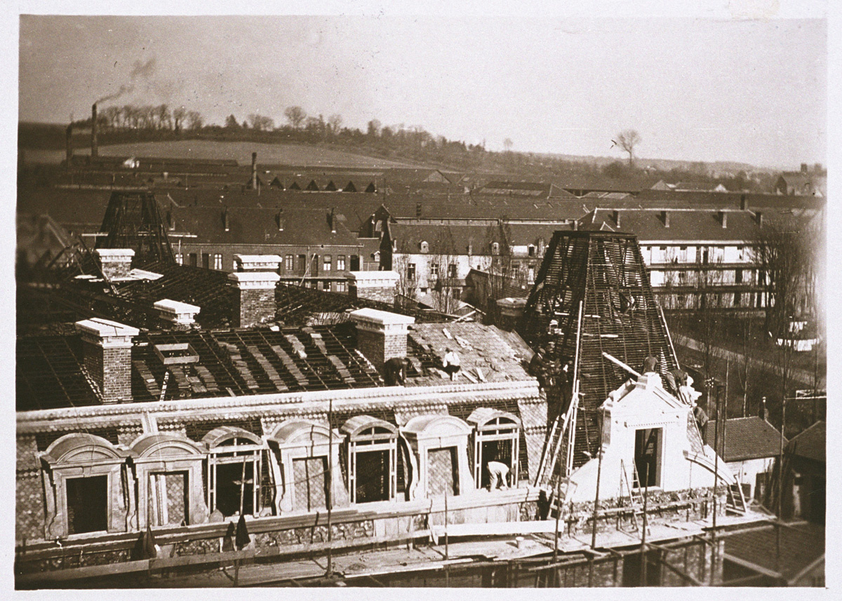 La photographie montre les couvreurs travaillant sur la charpente métallique de