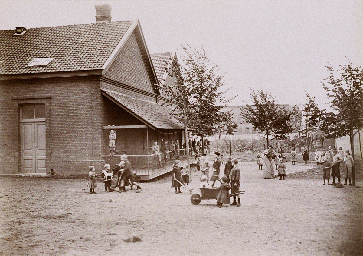 Des enfants jouent devant l’école du Familistère de Laeken.
