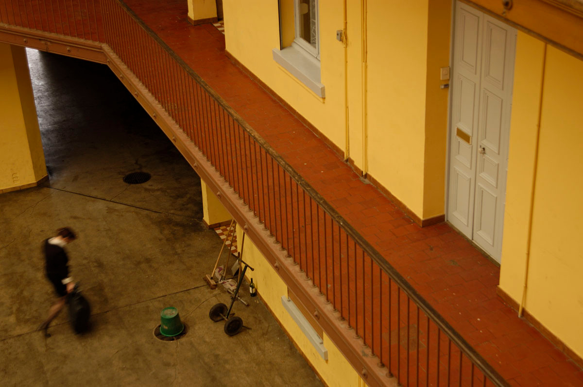 Un habitant traverse la cour de l’aile droite du Palais social.