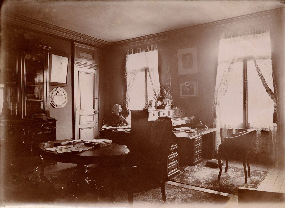La photographie montre Marie Moret dans le bureau de l’appartement de Godin.
