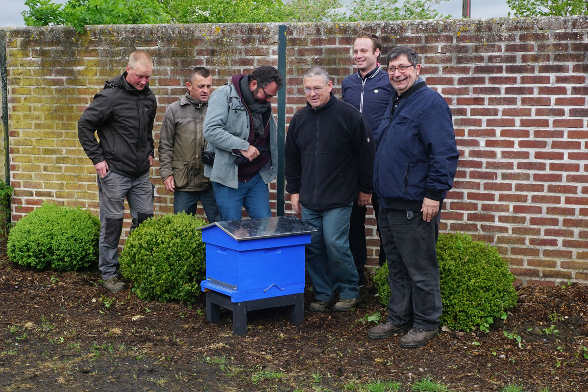 Un groupe est photographié derrière la ruche du jardin d'agrément