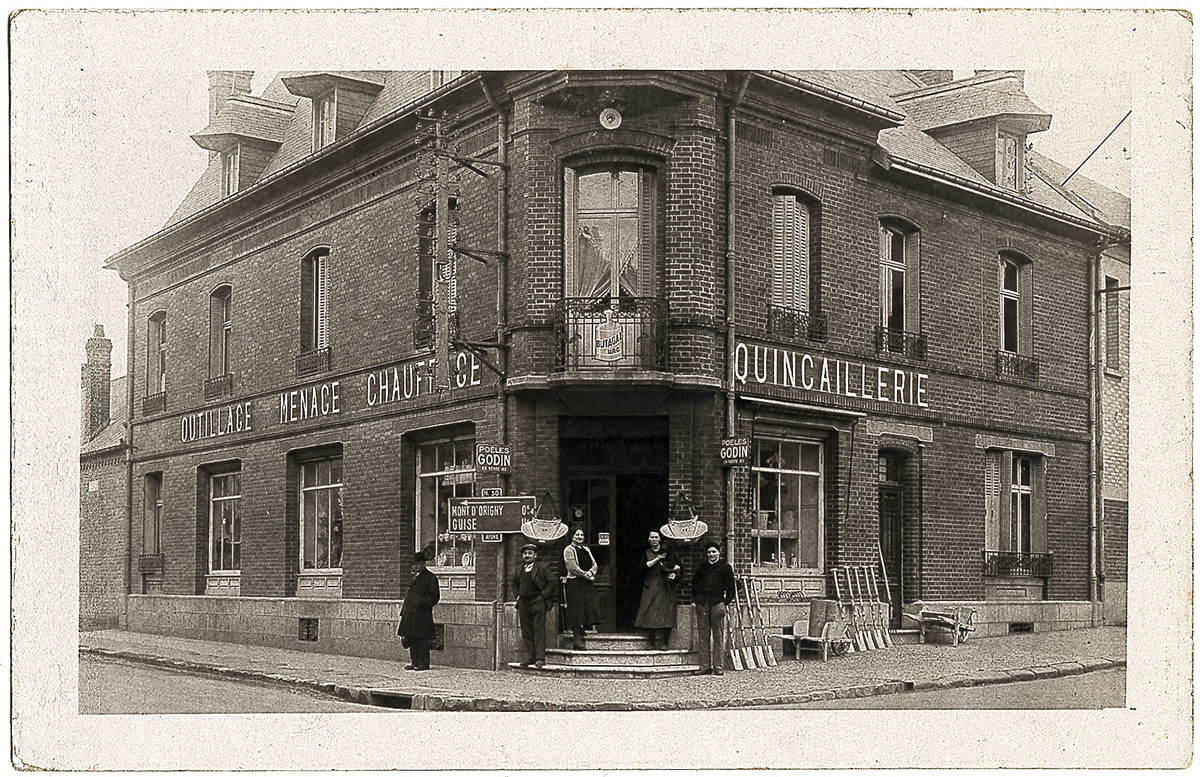La carte postale montre la façade d'un magasin de quincaillerie.