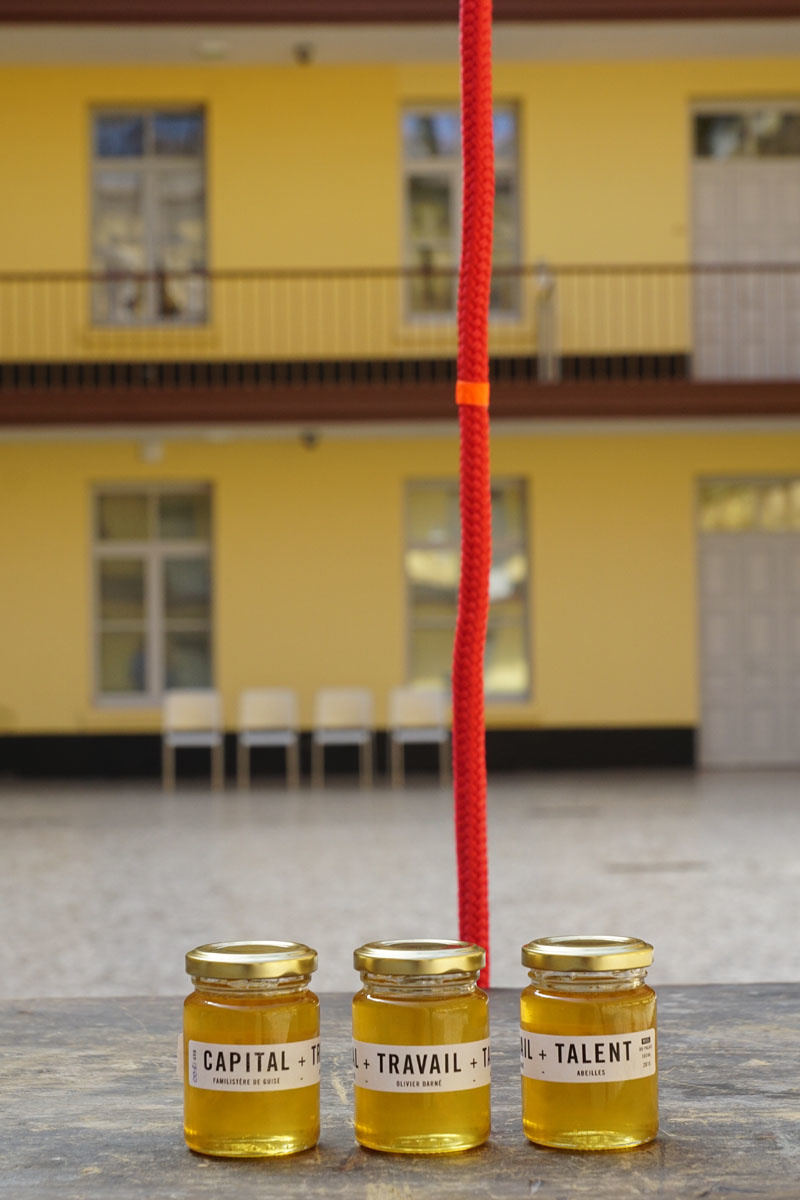 La photographie montre trois pots de miel dans la cour du pavillon central