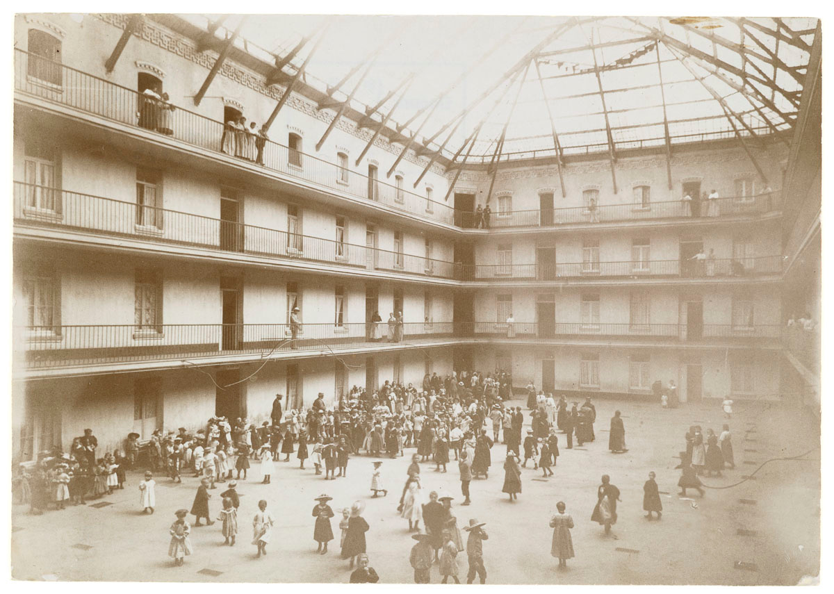 La photographie montre la cour du pavillon central envahie par des enfants.
