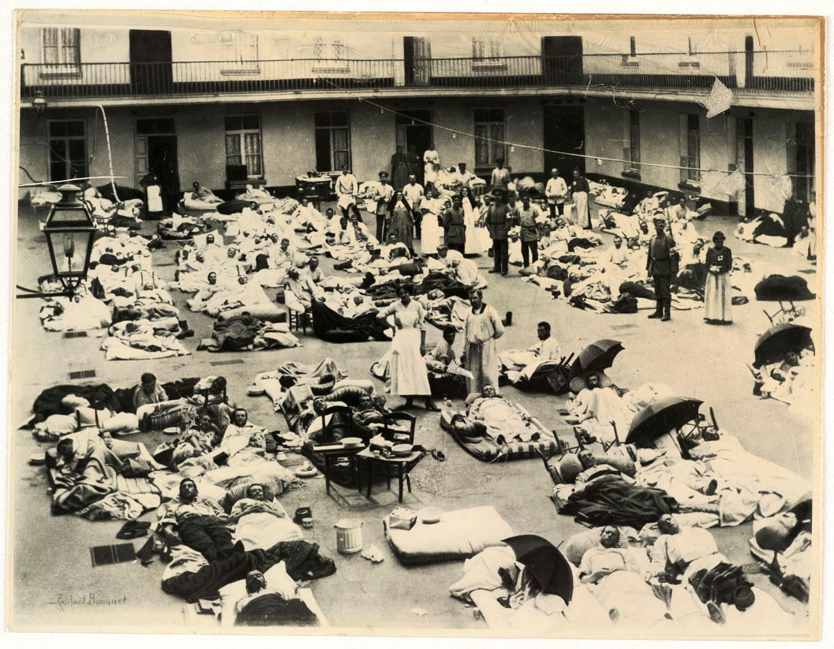 La photographie montre des soldats blessés couchés dans al cour du pavillon cent
