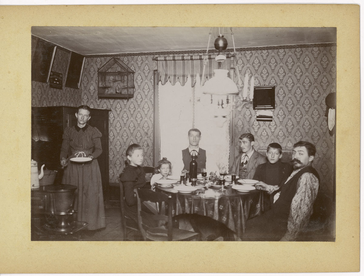 La photographie montre une famille attablée dans la cuisine d'un logement du Fam