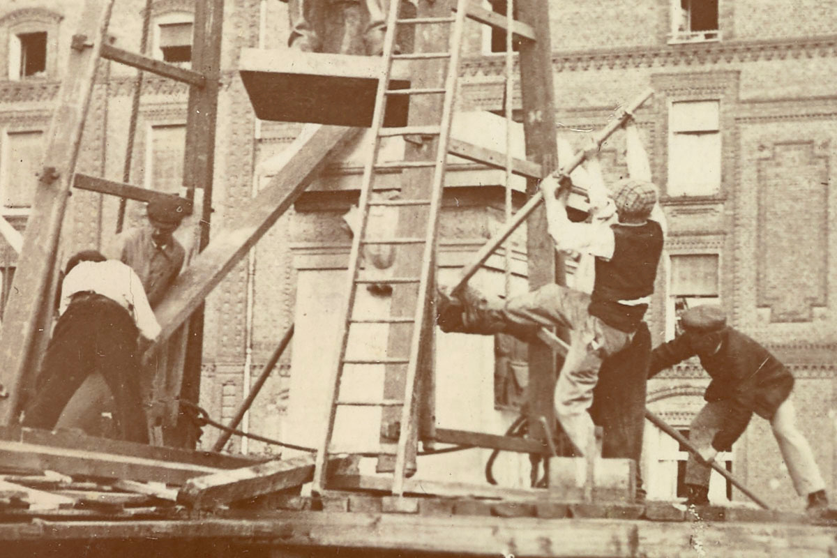 Détail de la photographie de l'installation de la statue de Godin sur son piédes