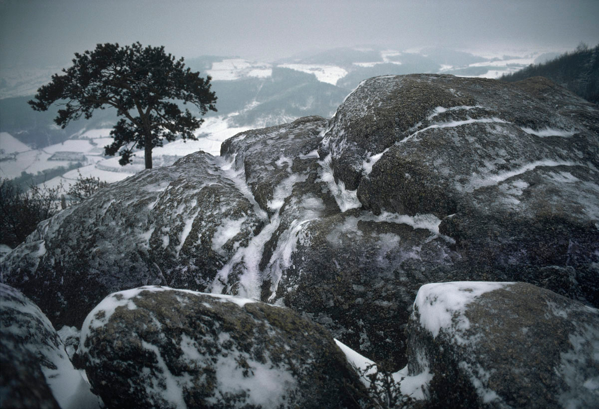 La photographie montre des rochers enneigés.