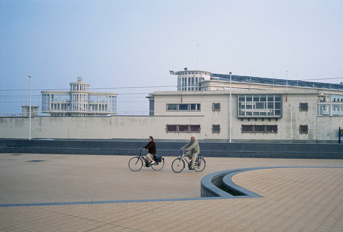 La photographie montre un couple en vélo sur un quai du port d'Ostende.