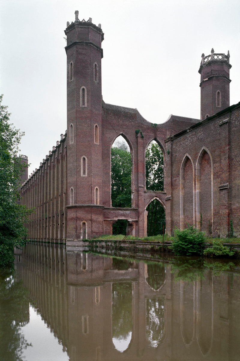 La photographie montre un édifice néo-gothique en ruines.