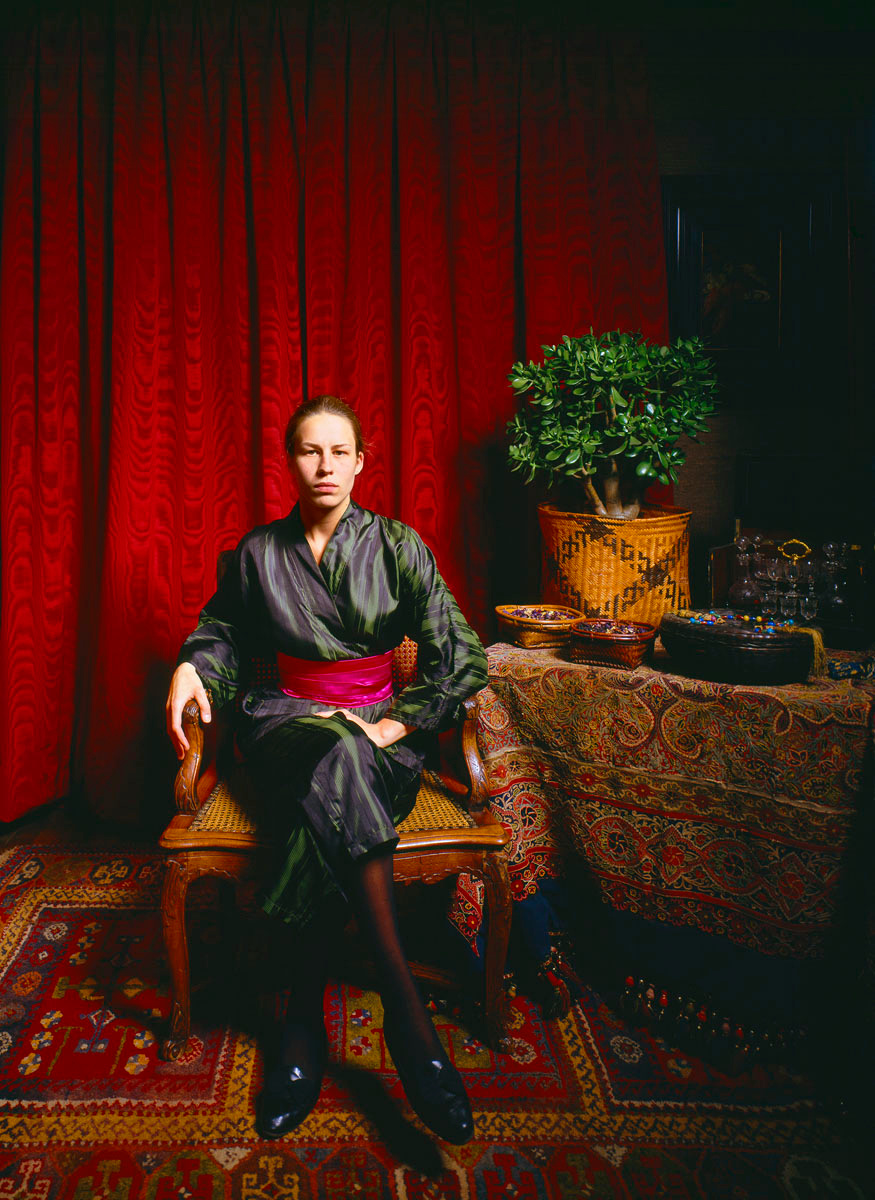 La photographie montre une jeune femme assise dans un intérieur.