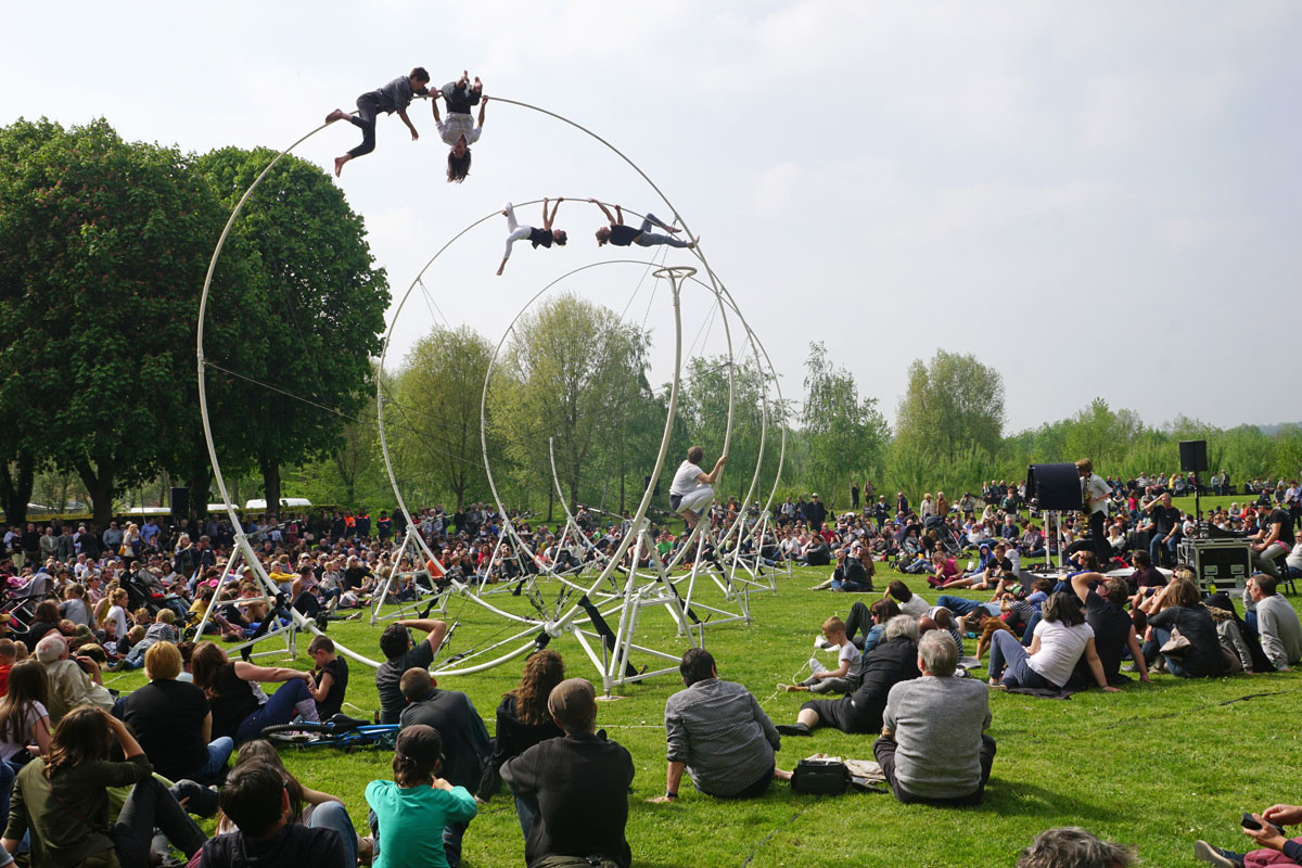 Acrobates sur une structure en spirale dans les jardins du Familistère avec publ