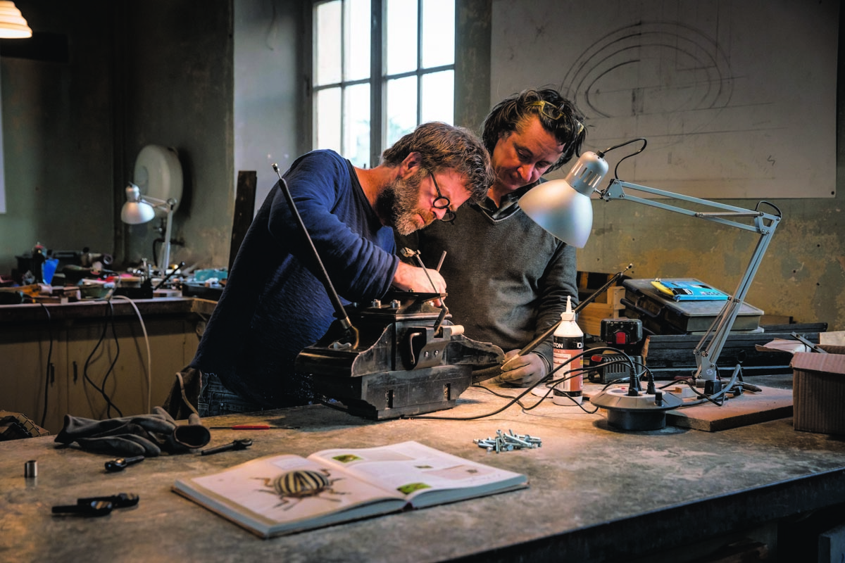 Photographie de deux hommes dans un atelier.