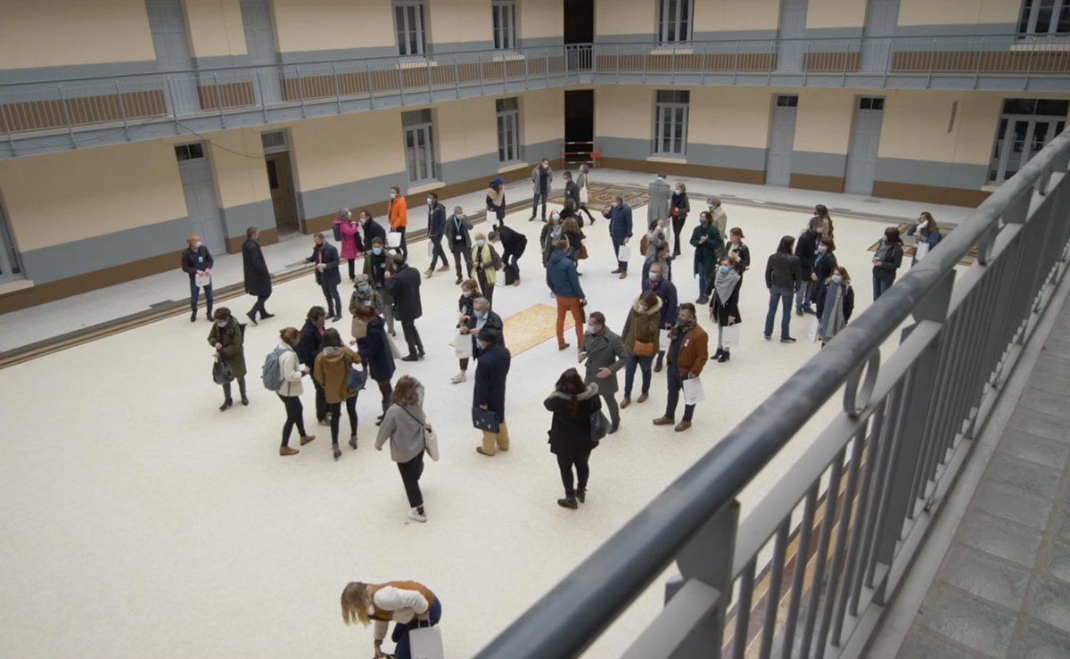 Vue d'un groupe de personnes dans la cour de l'aile gauche du Familistère