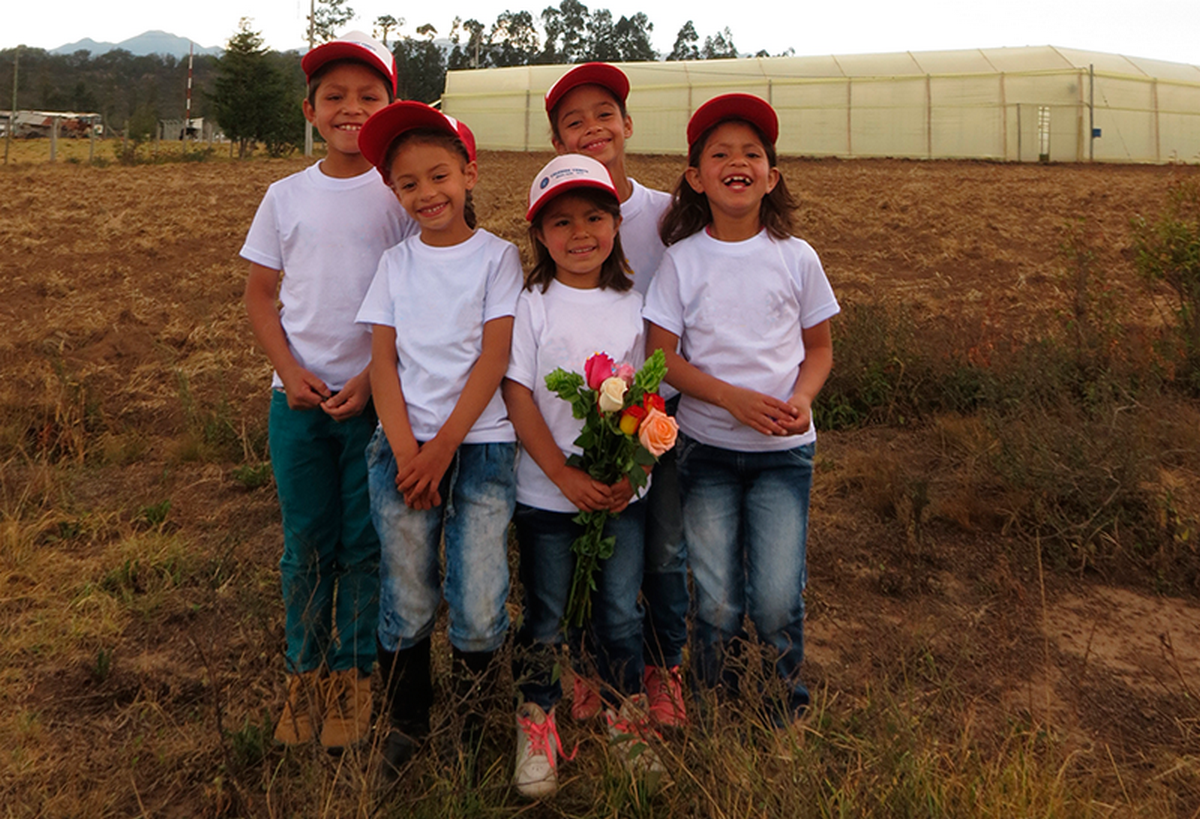 Élèves de la Megaulas Cohete de Nemocón tenant un bouquet de roses dont la vente