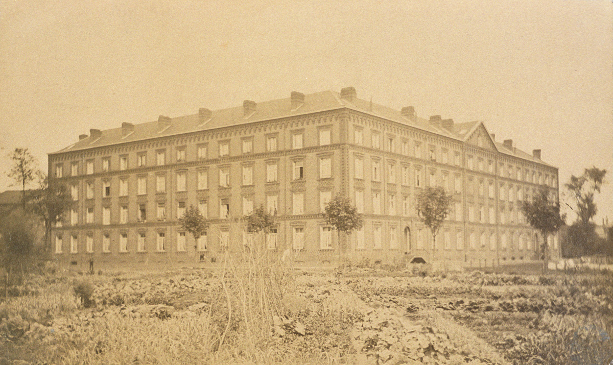 La photographie montre le pavillon Cambrai en arrière des jardins potagers
