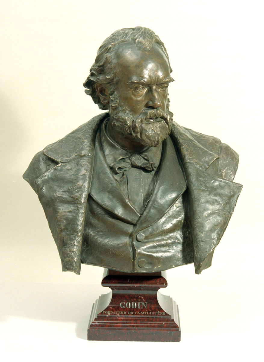 Le portrait en bronze montre Godin en buste, regardant vers la droite.