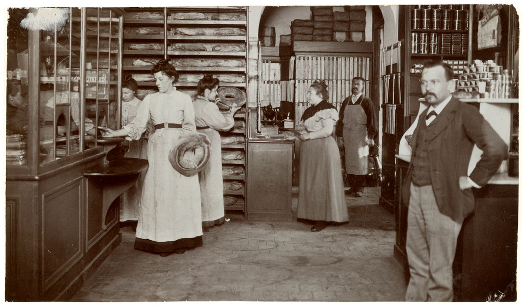 La photographie montre une vente de pain dans l'épicerie du Familistère