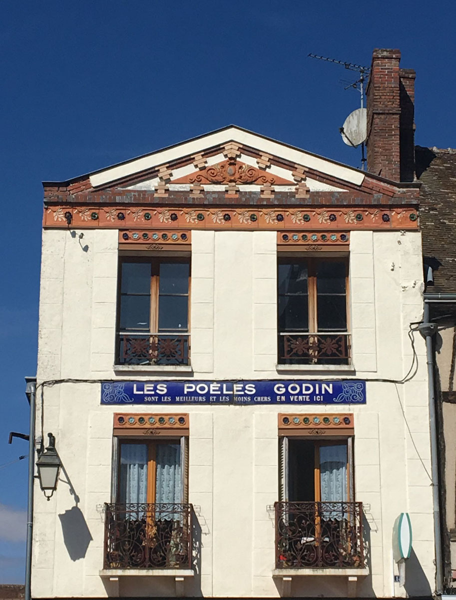 La photographie représente une enseigne "Godin" sur une maison de Nonancourt.