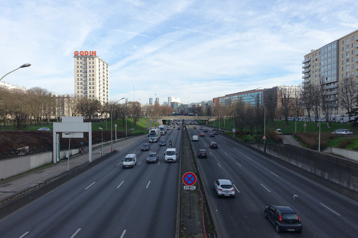 La photographie montre une enseigne Godin sur le périphérique de Paris.