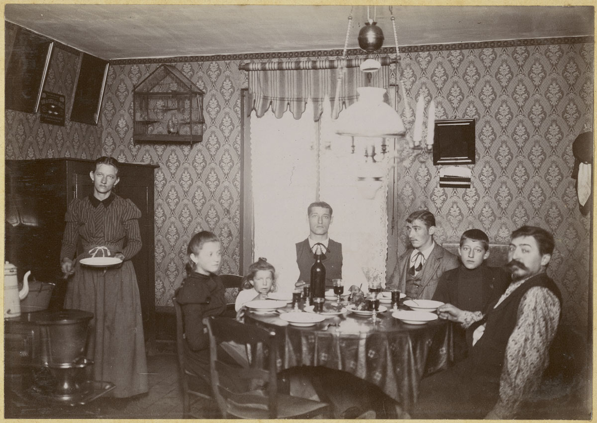 La photographie montre une famille attablée dans la cuisine d'un logement du Fam