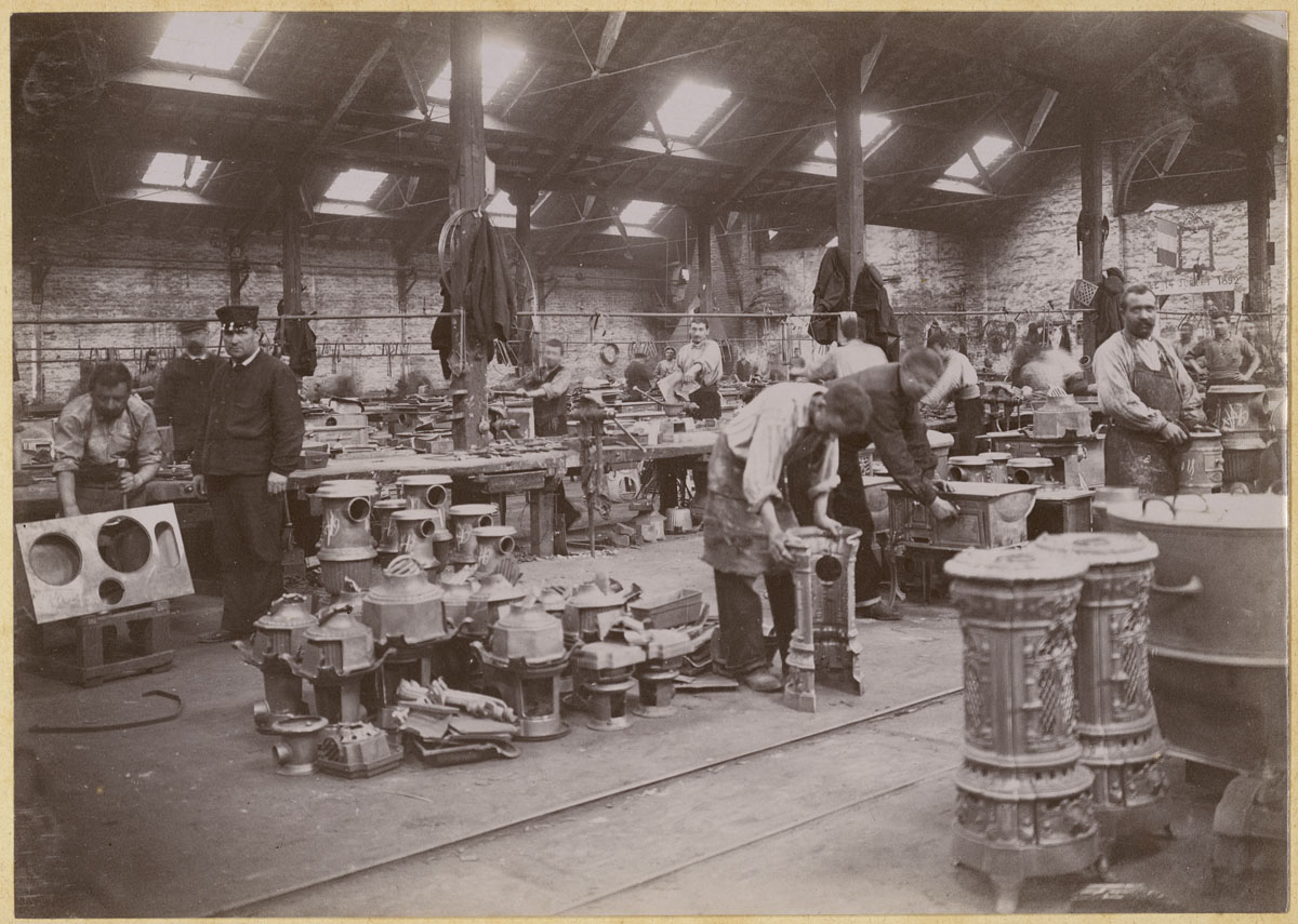 La photographie montre des monteurs au travail dans l'usine du Familistère