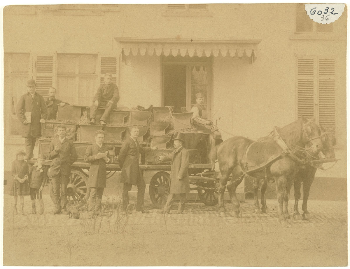 La photographie montre une voiture à cheval chargée de cuisinières.