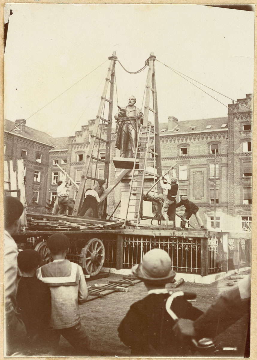 La photographie montre l'installation de la statue sur son piédestal.