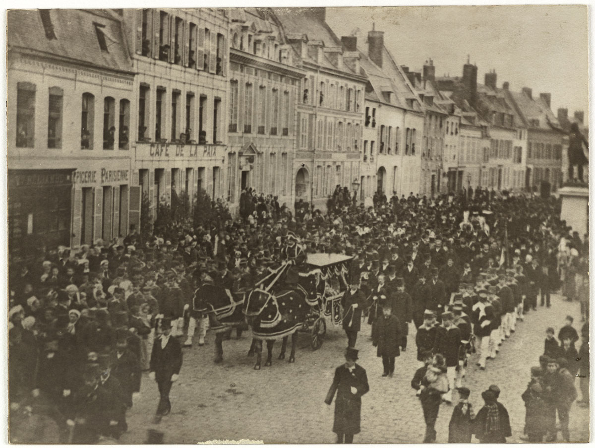 La photographie montre le convoi funèbre de Godin dans la ville de Guise.