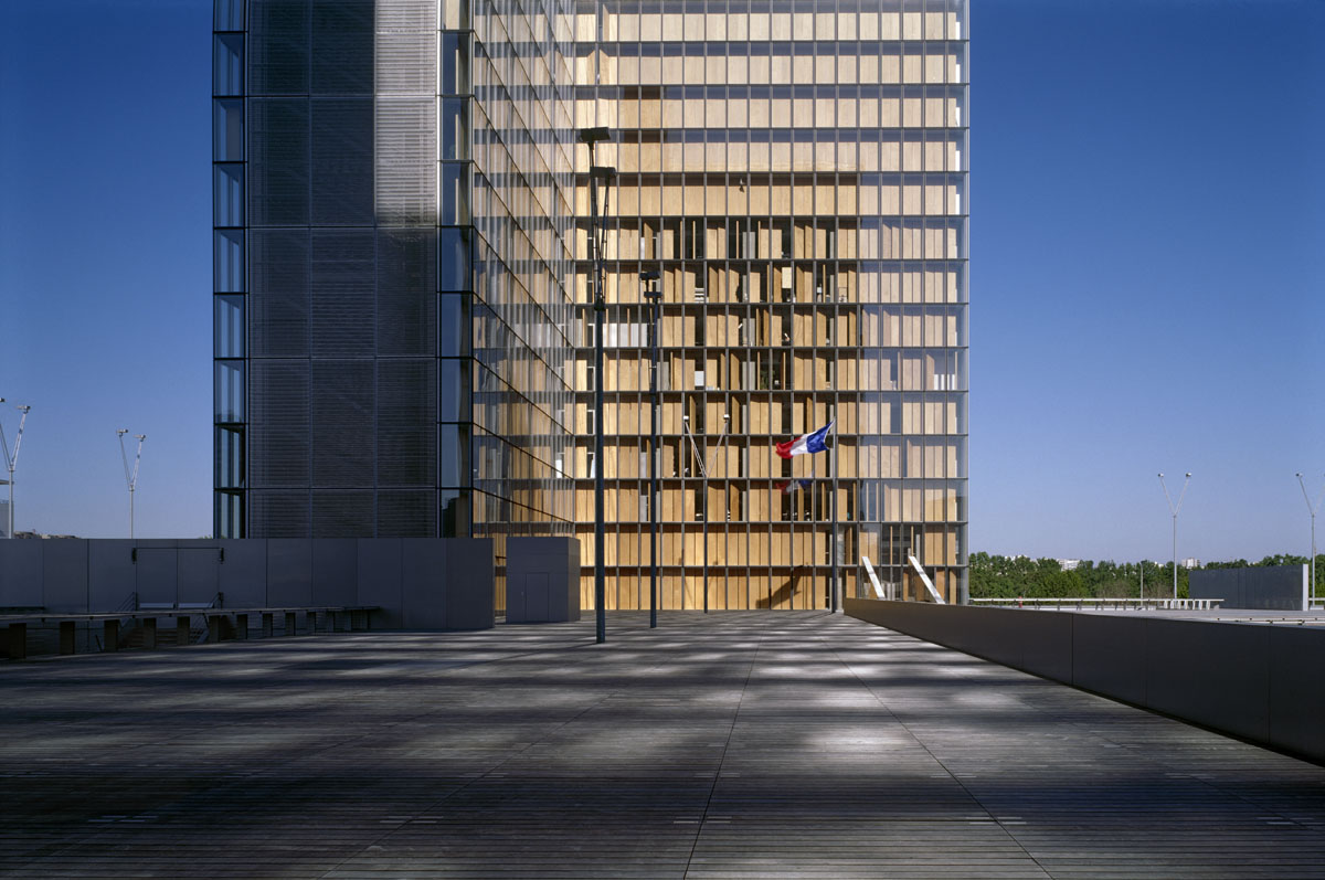 La photographie montre un drapeau tricolore devant une tour de la Bibliothèque n