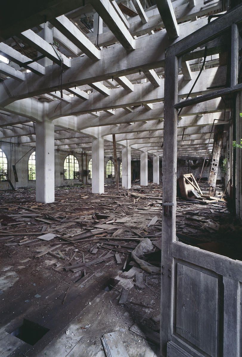 La photographie montre l'intérieur ruiné d'un bâtiment à structure de béton.