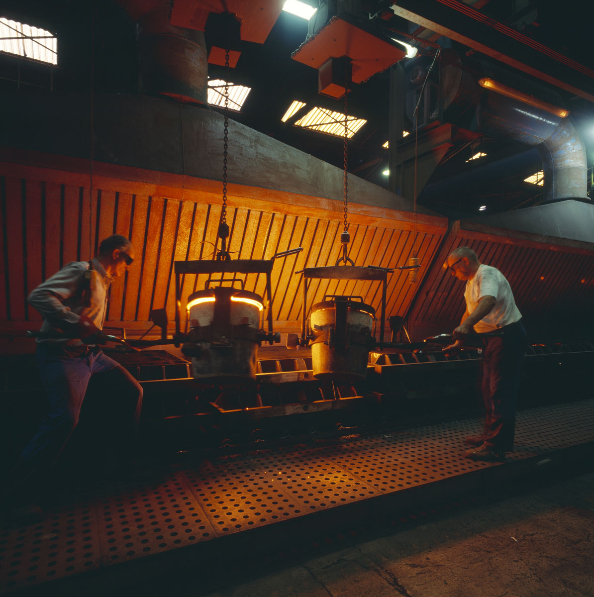 La photographie montre des mouleurs au travail dans l'usine Godin SA