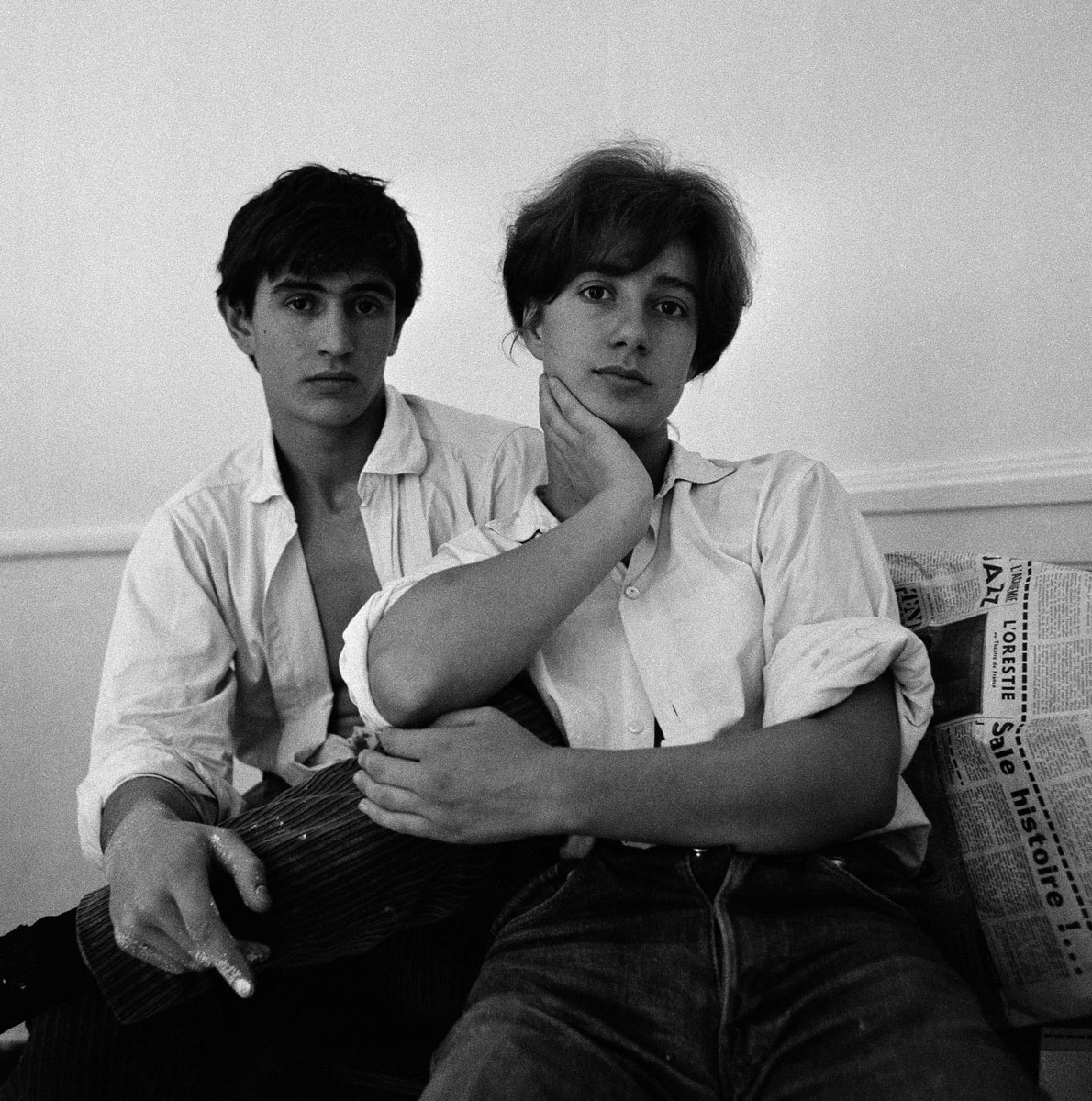 La photographie montre un jeune couple en chemises blanches.