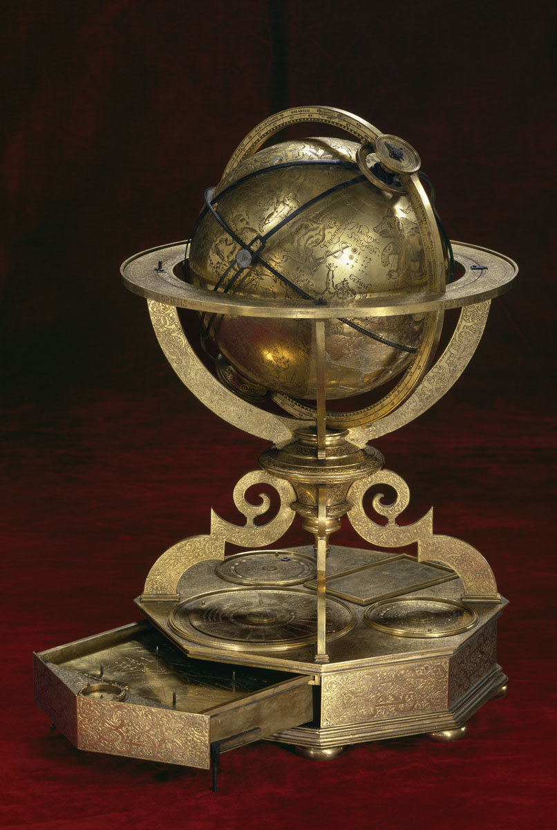 La photographie montre un globe céleste en métal cuivré.