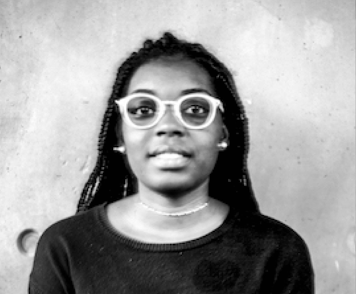 Portrait en buste d'une jeune femme noire à lunettes