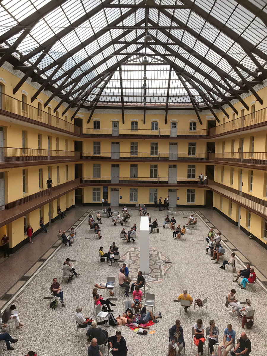 LA photographie montre un auditoire dans la cour du pavillon central.