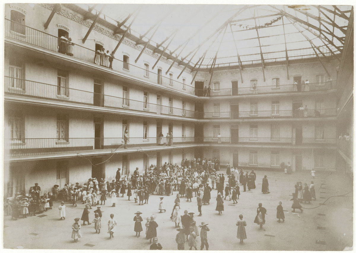 Vue d'écoliers rassemblés dans la cour du pavillon central.