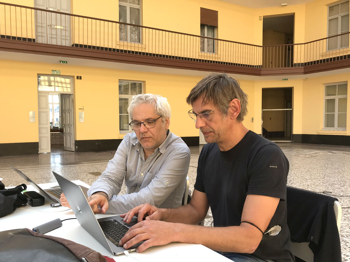 Vue de deux hommes assis à une table devant un ordinateur