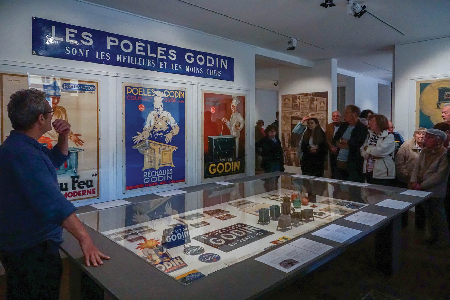 Visiteurs devant une vitrine d'objets publicitaires