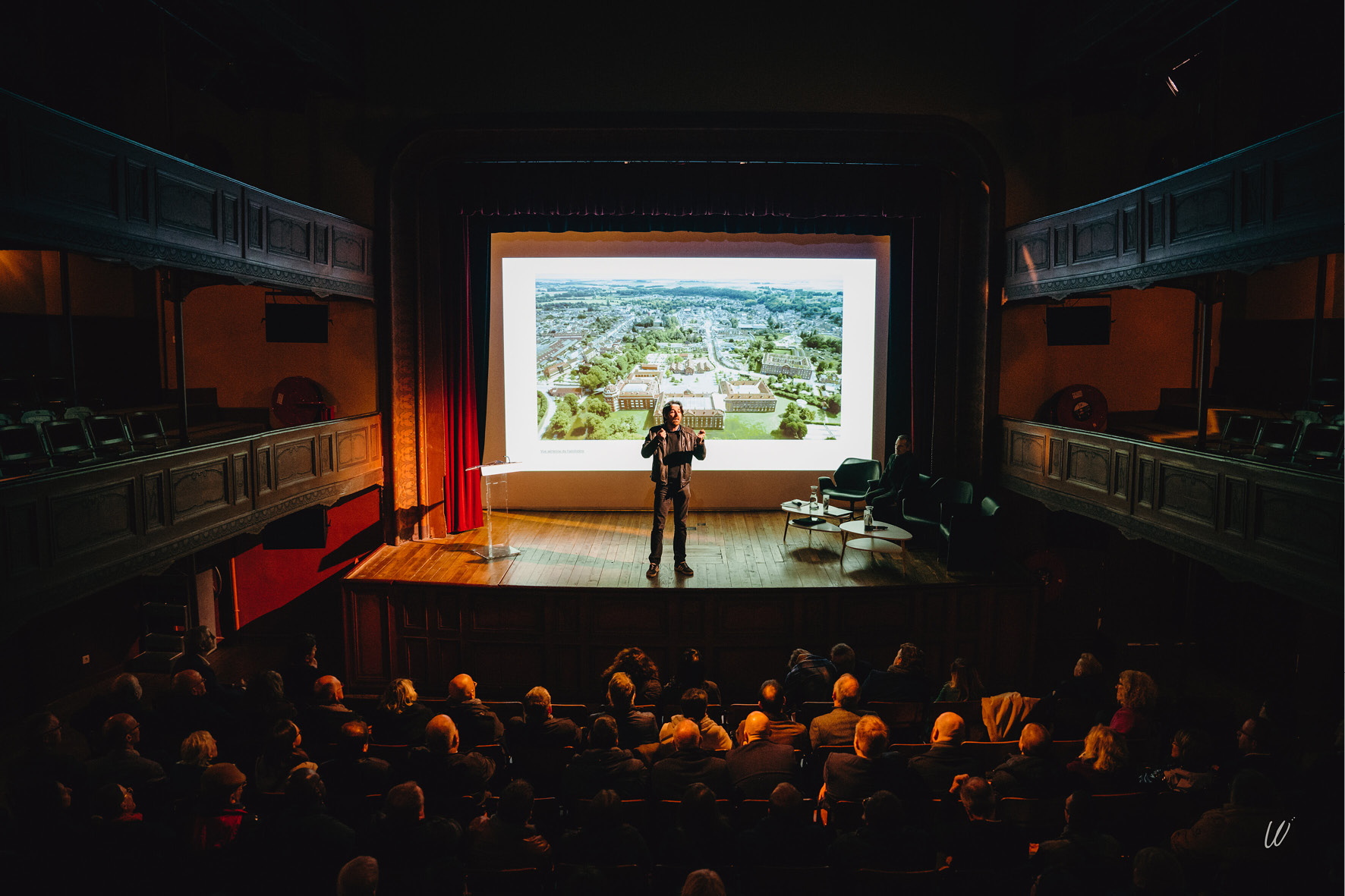 Sur la scène du théâtre un guide raconte l'histoire du site